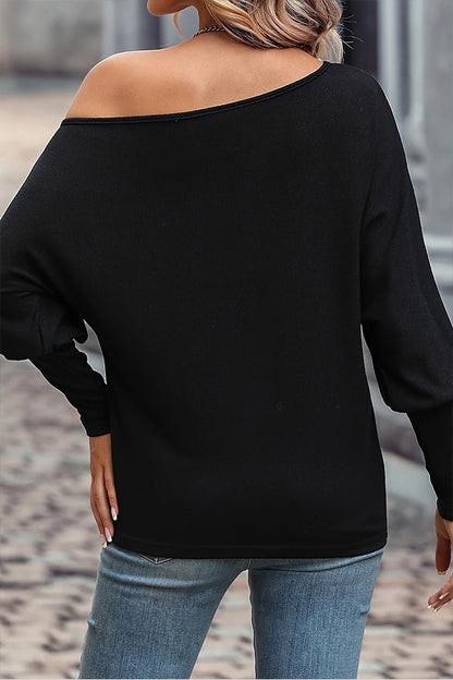 Blusa con cuello asimétrico y mangas abullonadas de perlas negras