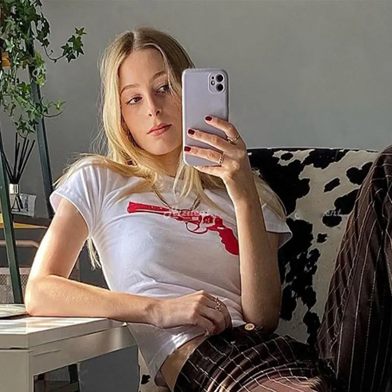 Camiseta corta con estampado divertido de pistola para mujer, estilo callejero europeo y americano, estilo Y2K, estilo casual, entallada y a la moda.