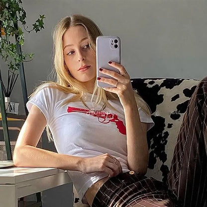 Camiseta corta con estampado divertido de pistola para mujer, estilo callejero europeo y americano, estilo Y2K, estilo casual, entallada y a la moda.