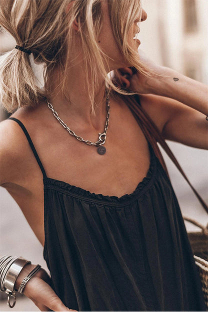 Mono negro con volantes, escote, tirantes, espalda descubierta y pierna ancha